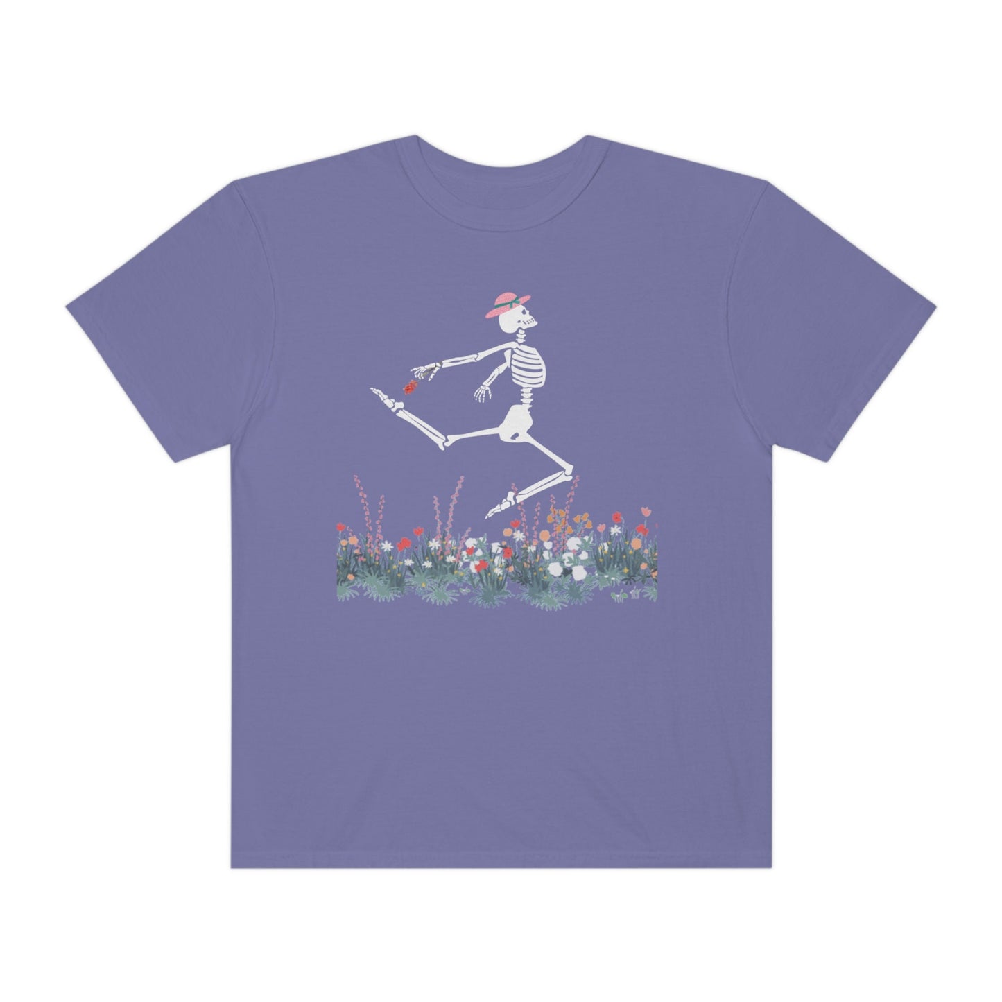 A cute purple colored shirt with a white female skeleton in a pink bonnet holding a red flower dancing in the air above a meadow of flowers.