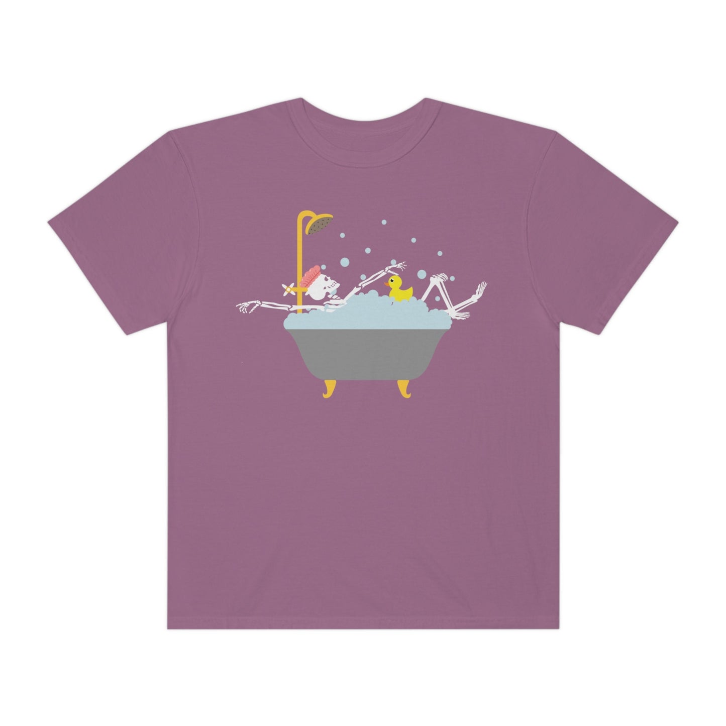 A woman wearing a cute purple colored shirt with a female skeleton wearing a pink bath cap is taking a bubble bath with a yellow rubber ducky, the bath is gold and gray colored and the air is filled with bubbles.