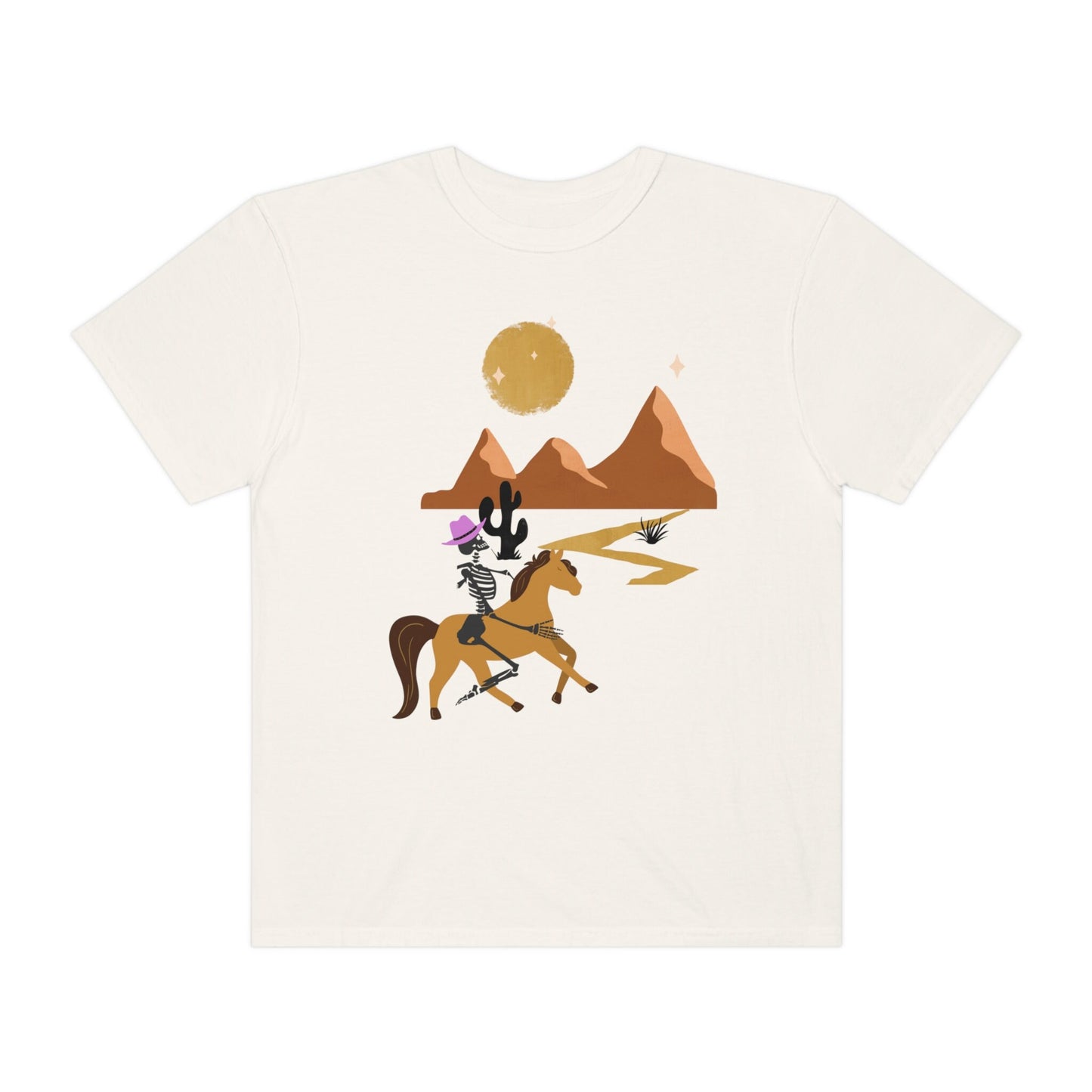 A vintage, ivory colored shirt with a skeleton cowgirl wearing a pink cowboy hat riding a brown horse through the eset at night, cacti and three mountains in the background with a full moon and stars in the sky.