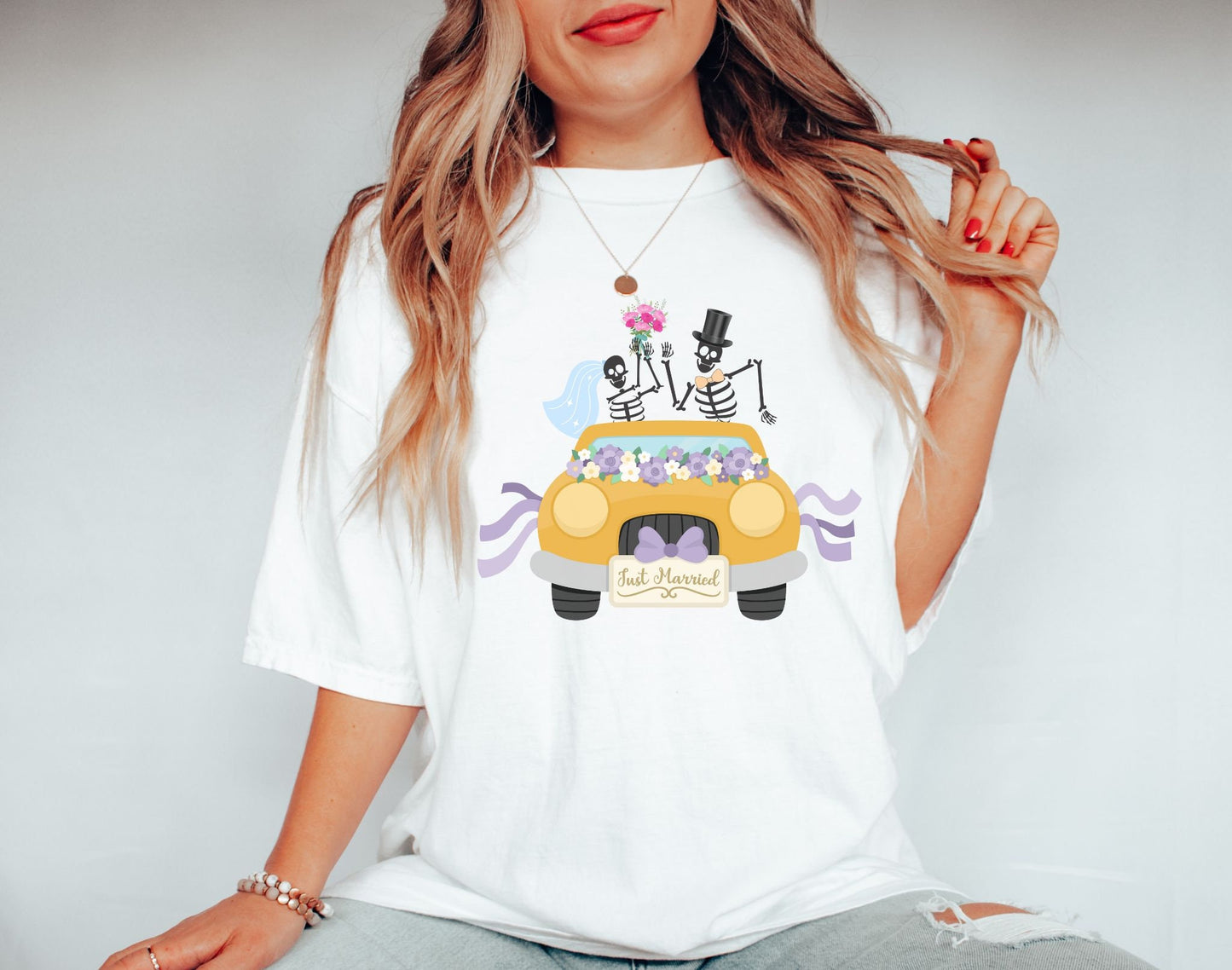 A woman wearing a cute white colored shirt with a newlywed couple holding flowers and waving goodbye from a gold colored car with the text Just Married on the front of the vehicle.