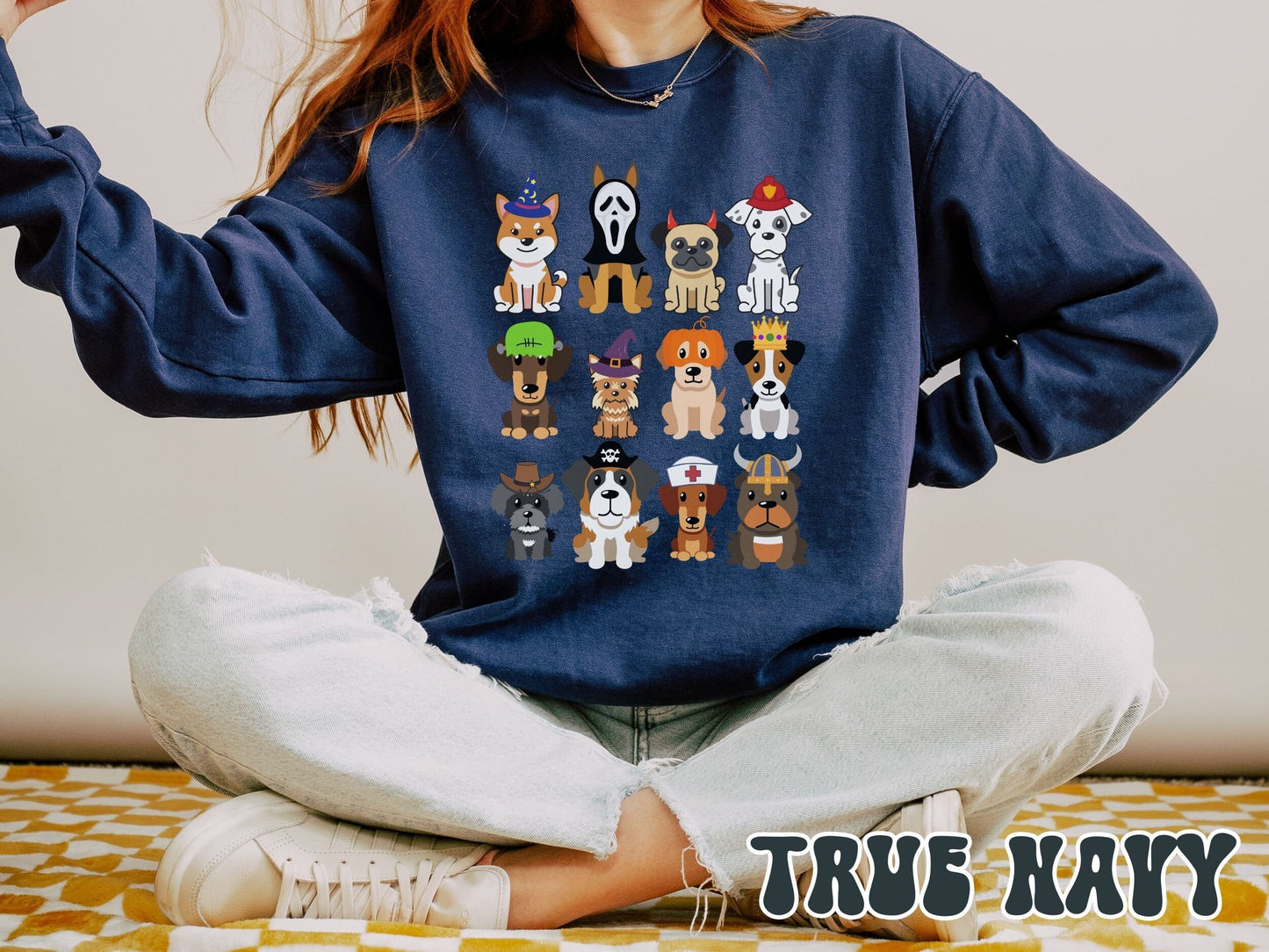 A woman wearing a cute, vintage true navy colored comfy Gildan sweatshirt with a four by three grid of different breeds of dogs dressed up in Halloween costumes. There is a dog dressed as a fireman and another as a nurse among others.
