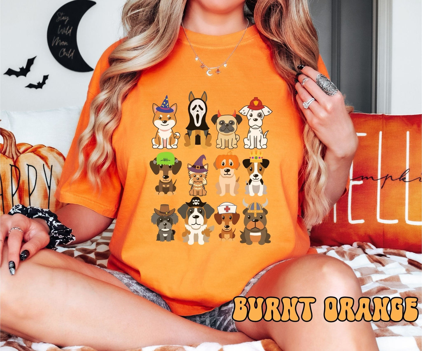 A woman wearing a cute, vintage burnt orange colored Comfort Colors t-shirt with a four by three grid of different breeds of dogs dressed up in Halloween costumes. There is a dog dressed as a fireman and another as a nurse among others.