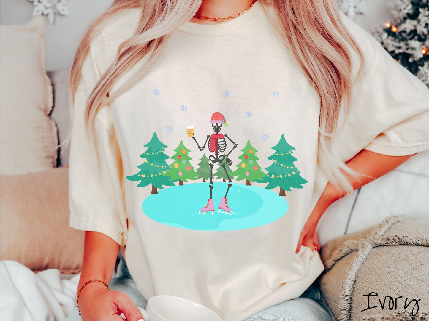A woman wearing a vintage, ivory colored shirt with a female skeleton wearing a red Santa hat, red scarf, red and pink ice skates, and holding a coffee, ice skating on a pond at night with snowflakes in the air and Christmas trees in the background.