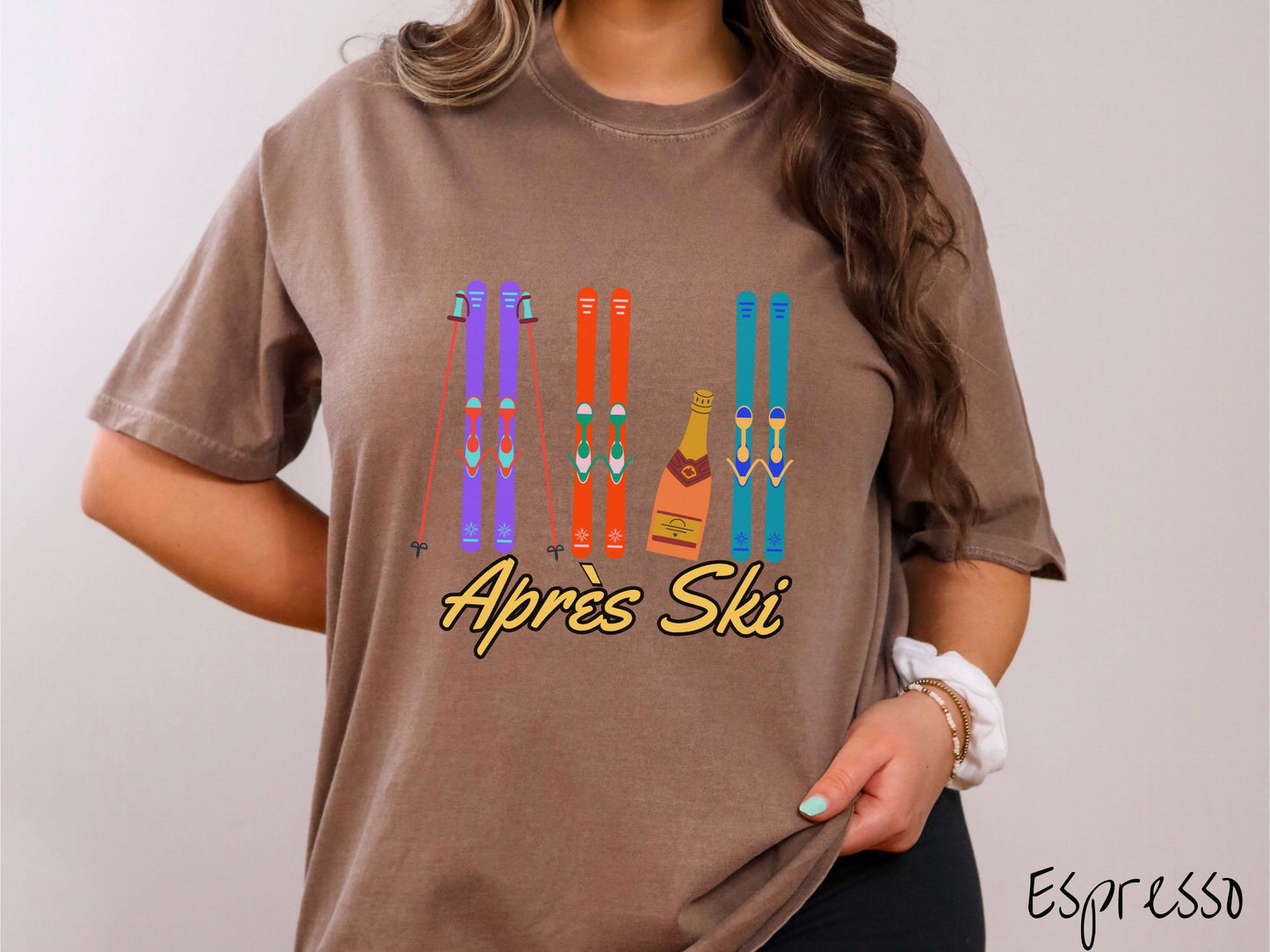 A woman wearing a vintage, espresso colored shirt with sets of purple, orange, and turquoise snow skis standing upright, and a big bottle of champagne next to them. Below the skis is the text Apres Ski which is French for After Skiing.