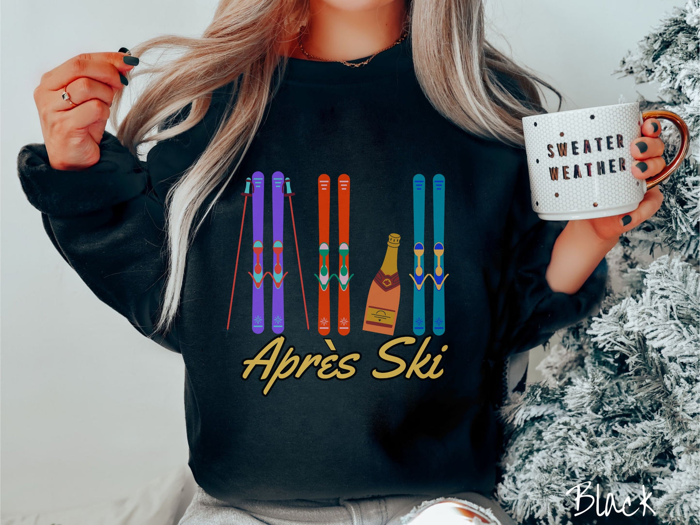 A woman wearing a vintage, black colored sweatshirt with sets of purple, orange, and turquoise snow skis standing upright, and a big bottle of champagne next to them. Below the skis is the text Apres Ski which is French for After Skiing.