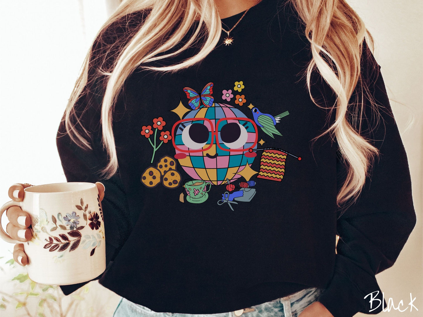 A woman wearing a cute black colored sweatshirt with a femsale face wearing glasses and smiling