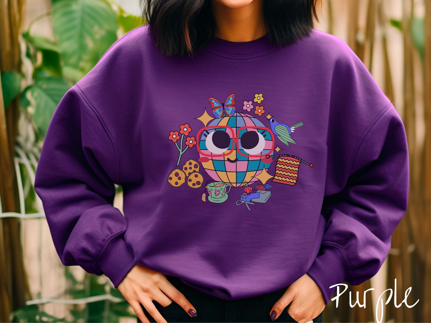 A woman wearing a cute purple colored sweatshirt with a femsale face wearing glasses and smiling