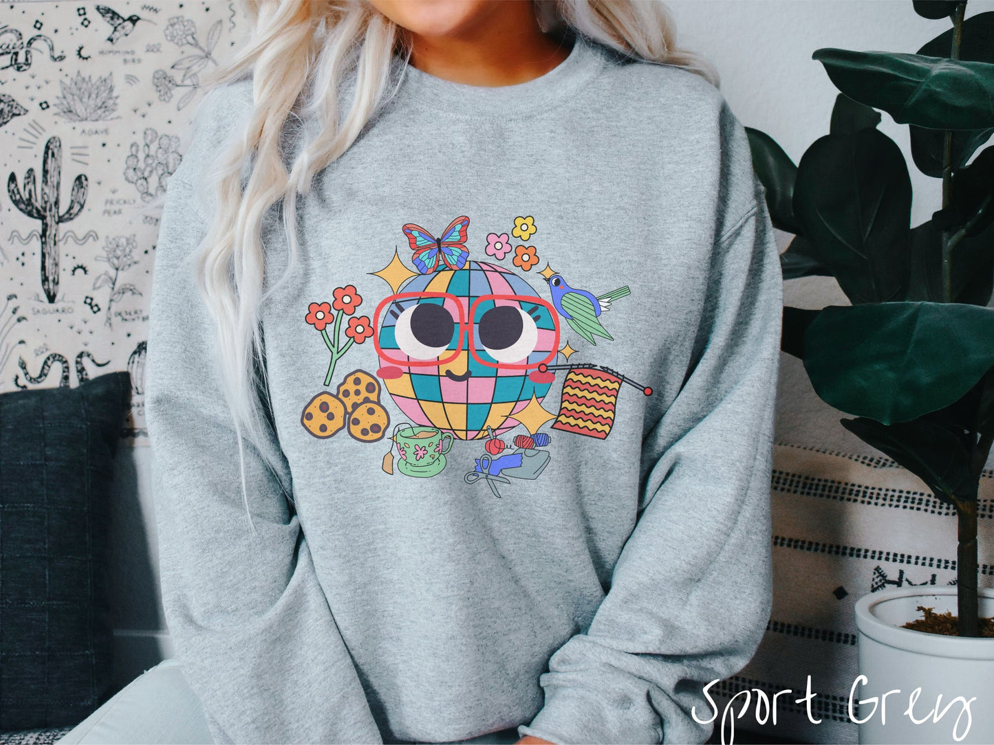A woman wearing a cute sport grey colored sweatshirt with a femsale face wearing glasses and smiling