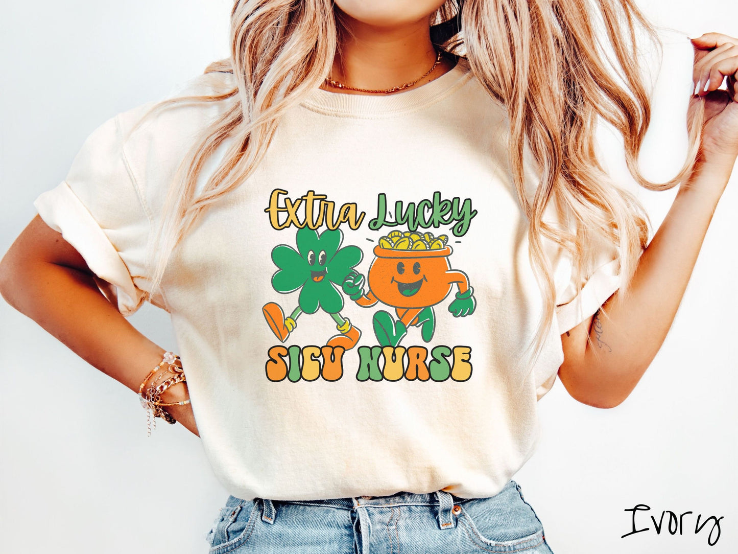 A woman wearing a vintage, ivory colored shirt with the text Extra Lucky SICU Nurse in yellow, orange, and green font. Between the text are a green clover and orange pot of gold smiling and walking together in step.