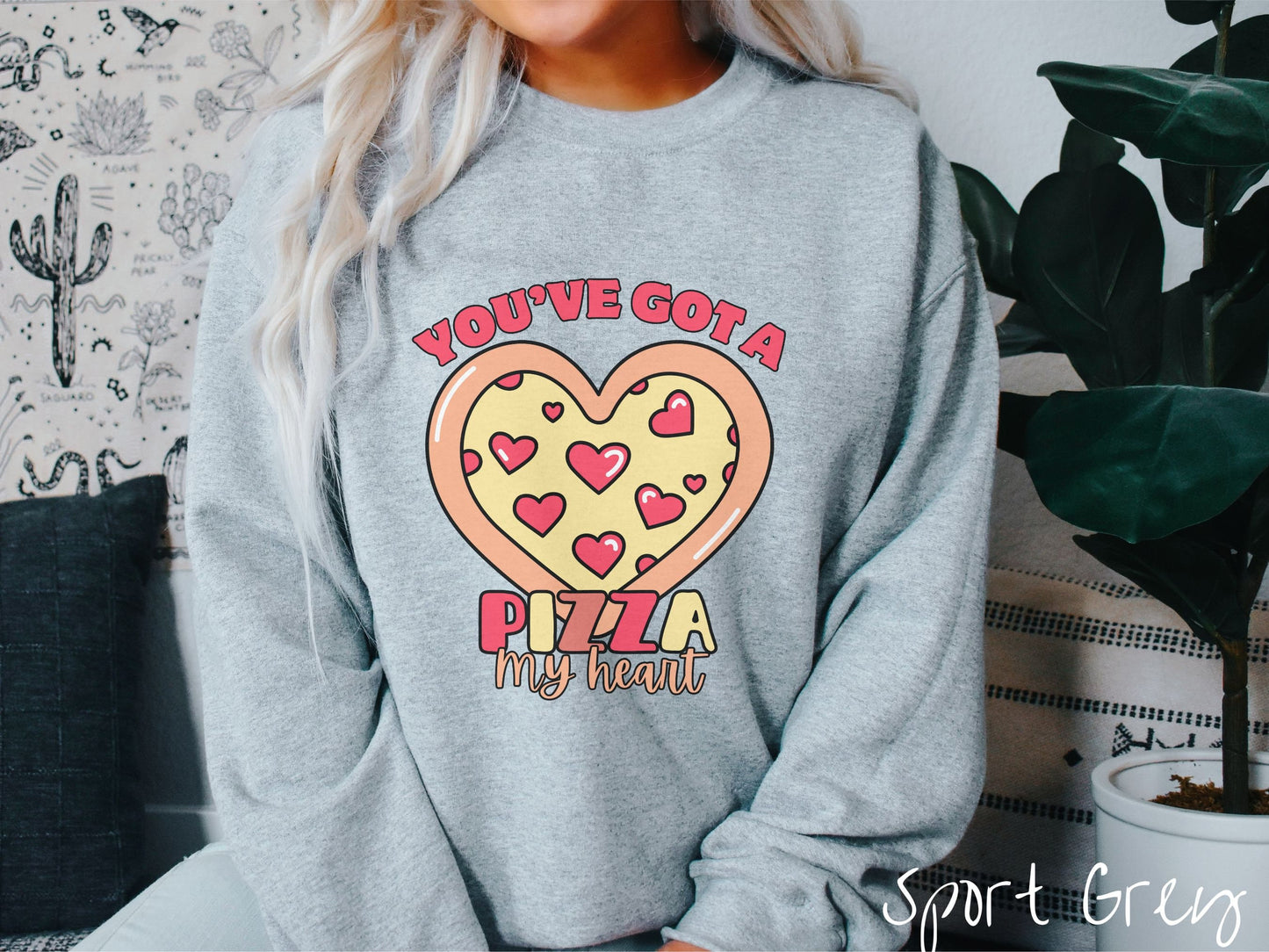A woman wearing a cute sport grey colored sweatshirt with red text Youve Got a Pizza My Heart around a heart-shaped pizza with heart-shaped red pepperonis.
