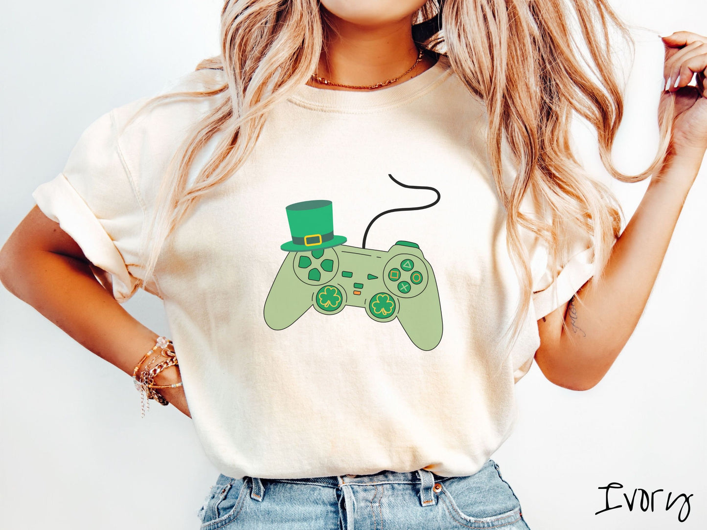 A woman wearing a vintage, ivory colored shirt with a black video game controller with green buttons and joysticks, the analog control sticks are in the shape of green leaf clovers, and there is a green top hat hanging off the top left trigger.