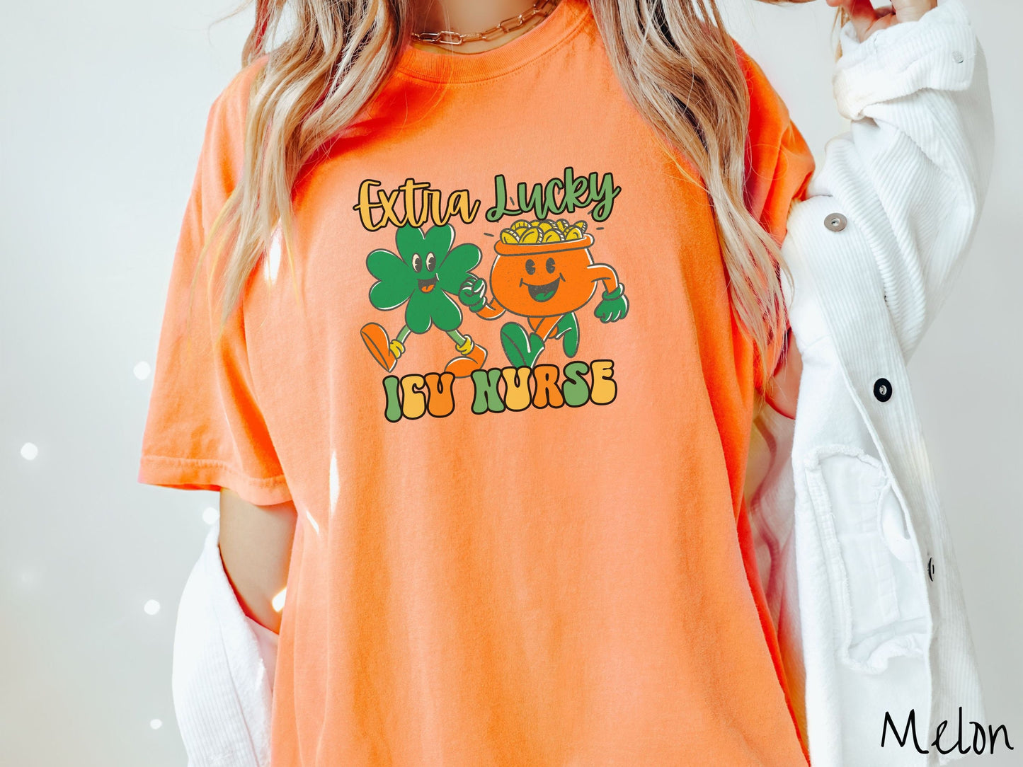 A woman wearing a vintage, melon colored shirt with the text Extra Lucky ICU Nurse in yellow, orange, and green font. Between the text are a green clover and orange pot of gold smiling and walking together in step.
