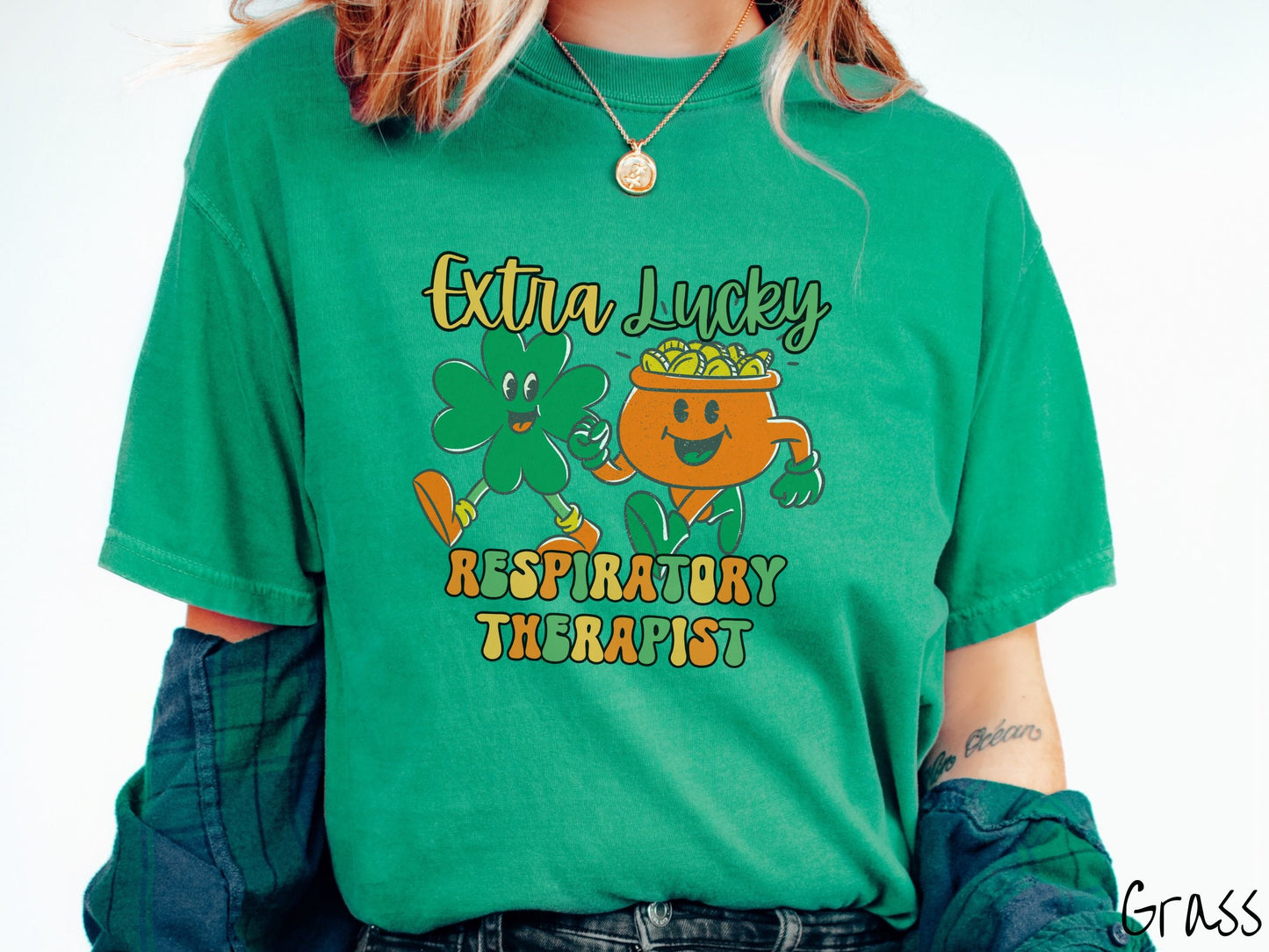 A woman wearing a vintage, grass colored shirt with the text Extra Lucky Respiratory Therapist in yellow, orange, and green font. Between the text are a green clover and orange pot of gold smiling and walking together in step.