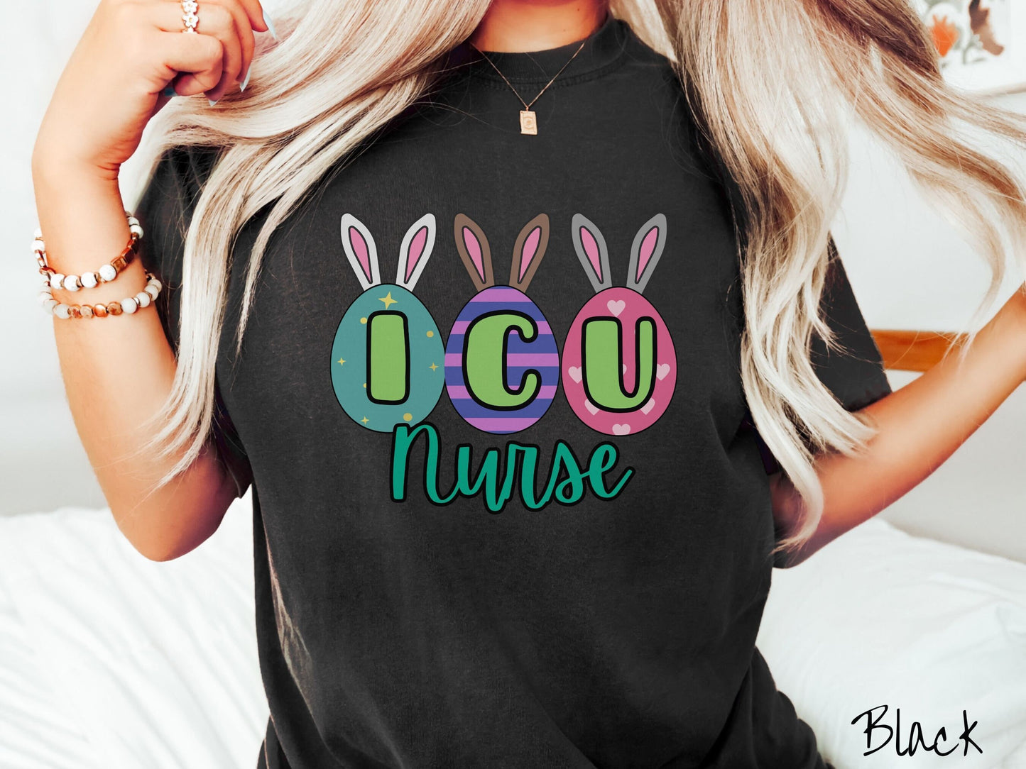 A woman wearing a cute, vintage black colored shirt with three colorful easter eggs next to each other with the letters I, C, and U inside. Each egg has a pair of bunny rabbit ears, one is white, the middle brown, and the left gray.
