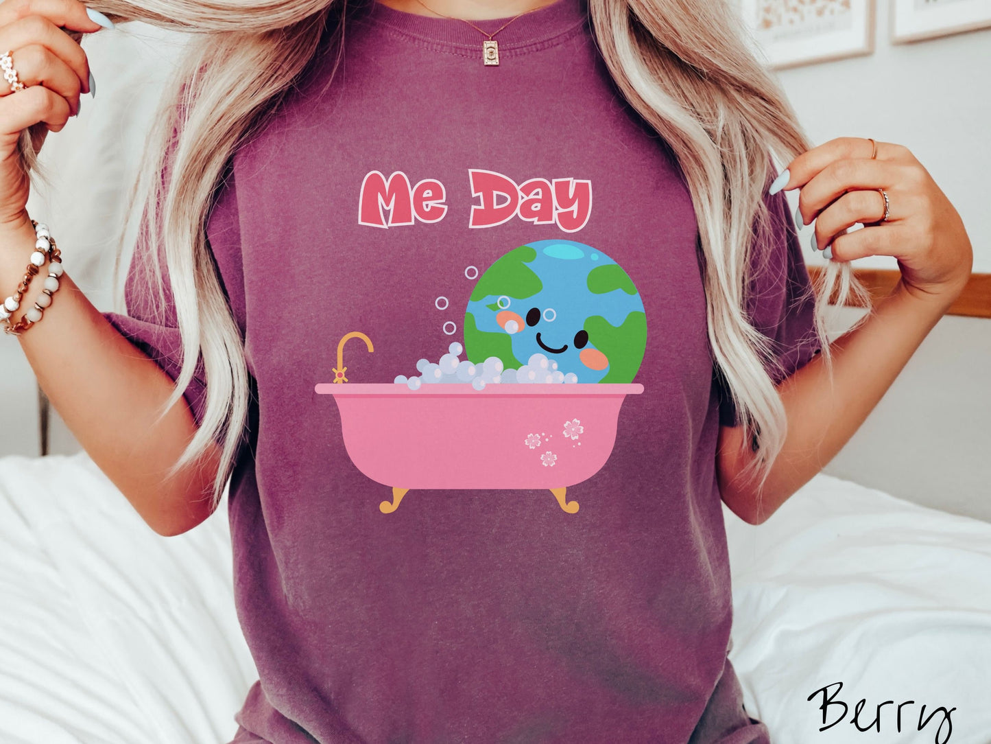 A woman wearing a cute, vintage berry colored Comfort Colors shirt with the text Me Day in red font across the top. Below that is the Earth with a smiling face sitting in a pink bathtub enjoying a bubble bath.