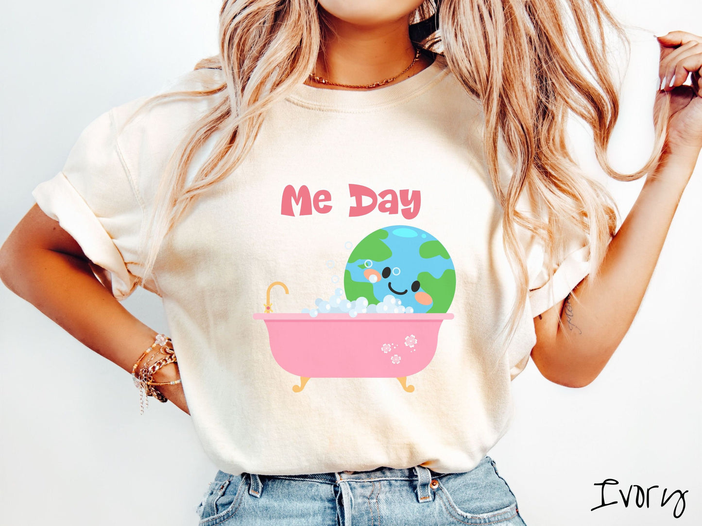 A woman wearing a cute, vintage ivory colored Comfort Colors shirt with the text Me Day in red font across the top. Below that is the Earth with a smiling face sitting in a pink bathtub enjoying a bubble bath.