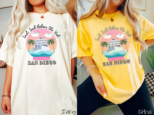 Two women wearing cute, vintage ivory and citrus colored Comfort Colors t-shirts with text Last Sail before the Veil and Katie’s Bachelorette San Diego, with a picture of a white cruise ship off the coast with palm trees and a sunny sky.