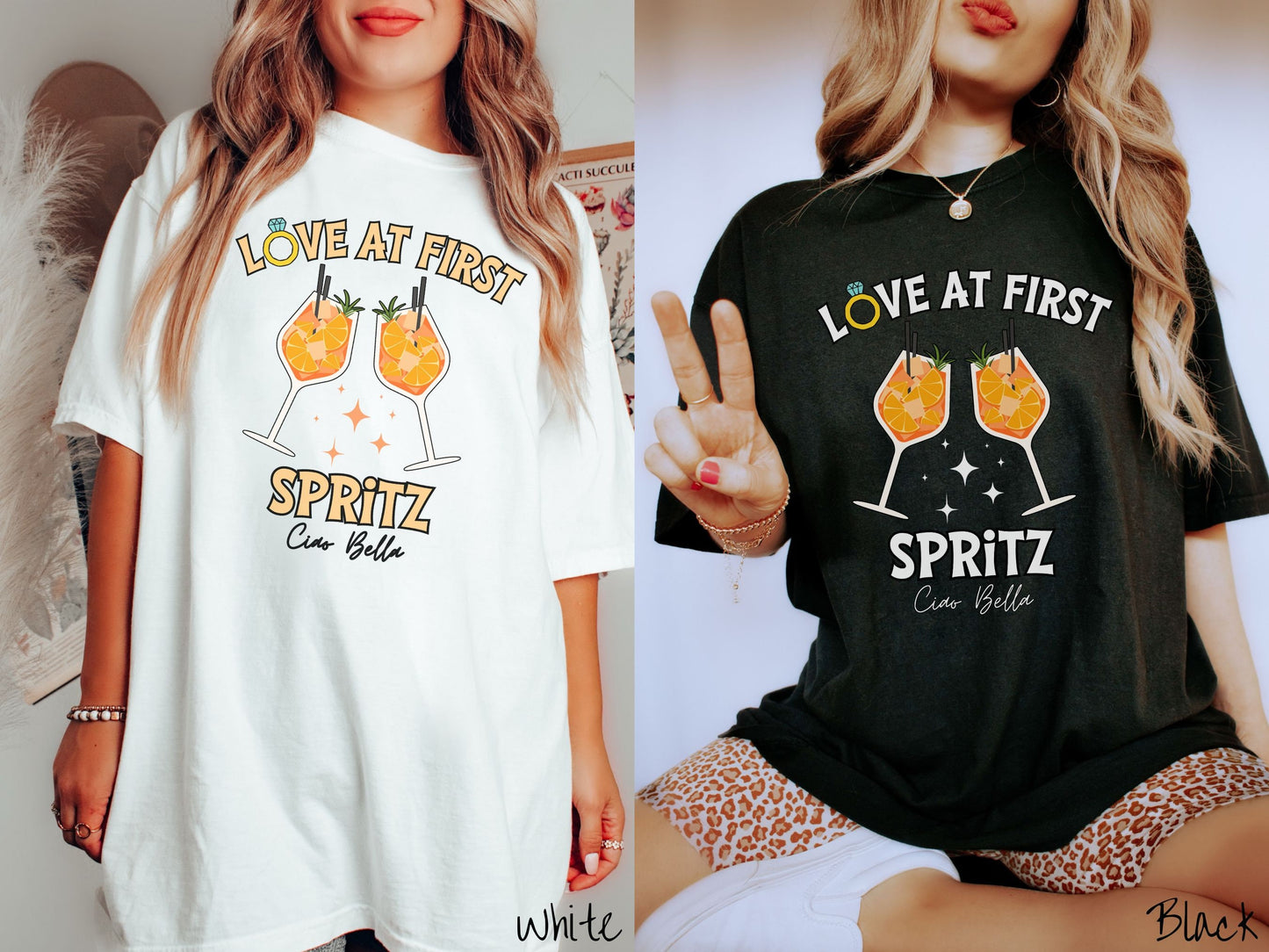 Two women wearing cute, vintage white and black colored Comfort Colors t-shirts with text Love at First Spritz in yellow font, the O in Love is a diamond wedding ring. Between the text are two cocktail glasses of aperol spritz toasting.