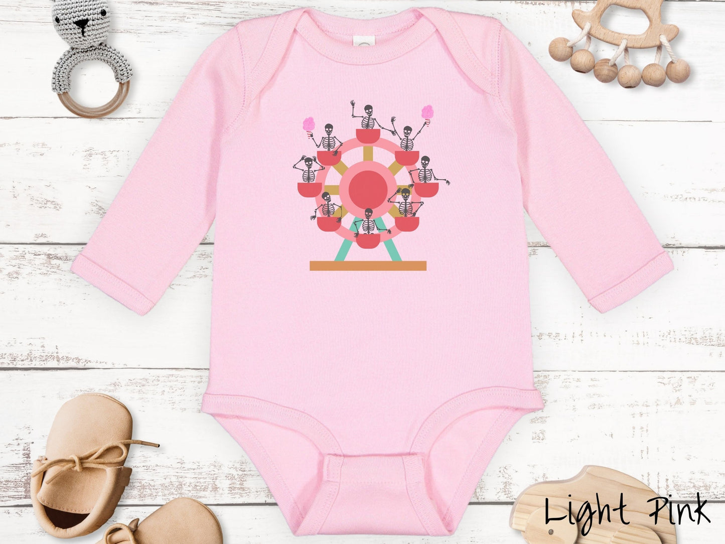 A cute light pink colored body suit with a ferris wheel filled with black skeletons waving and holding cotton candy as they go around the ride.