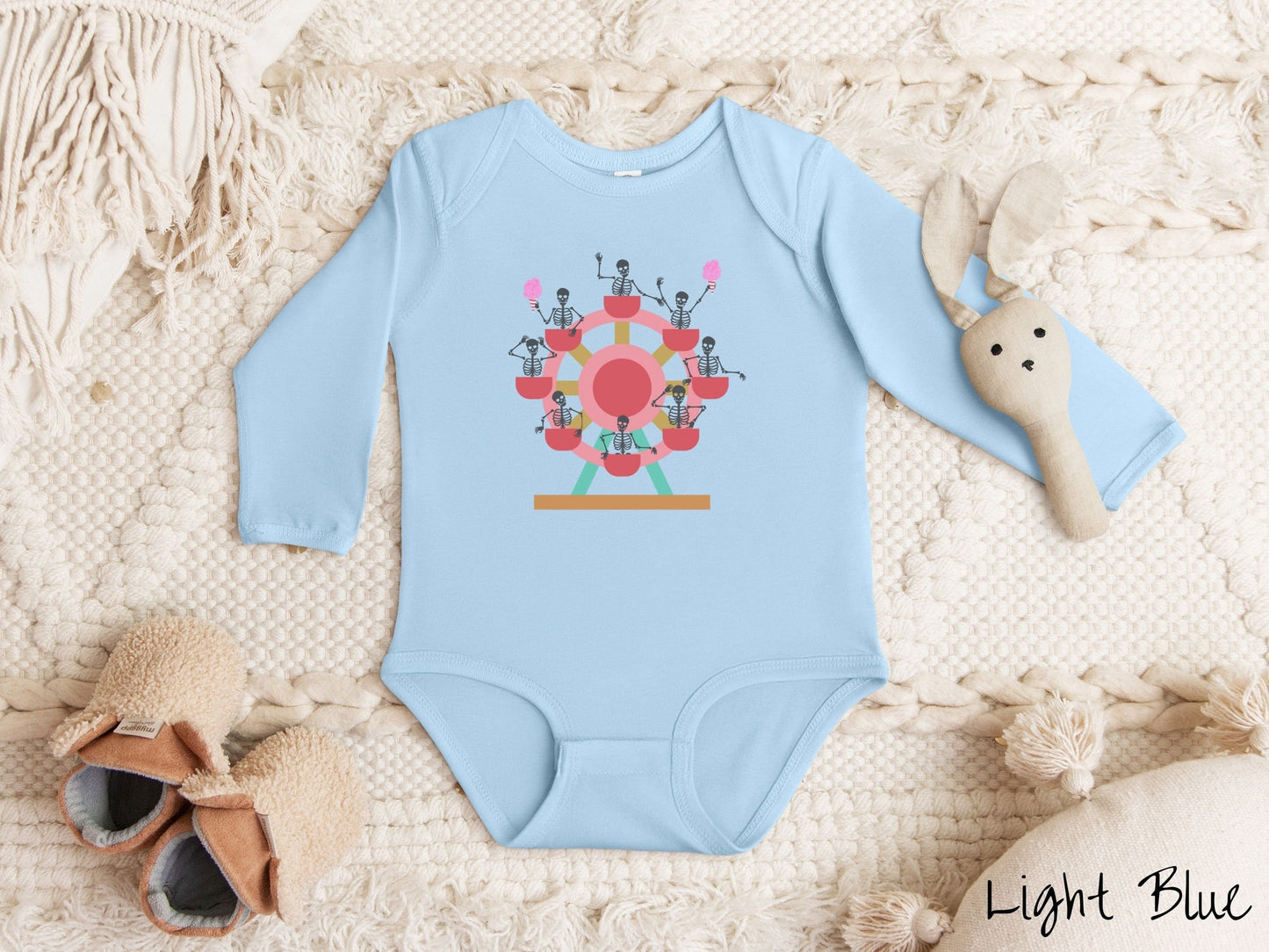 A cute light blue colored body suit with a ferris wheel filled with black skeletons waving and holding cotton candy as they go around the ride.