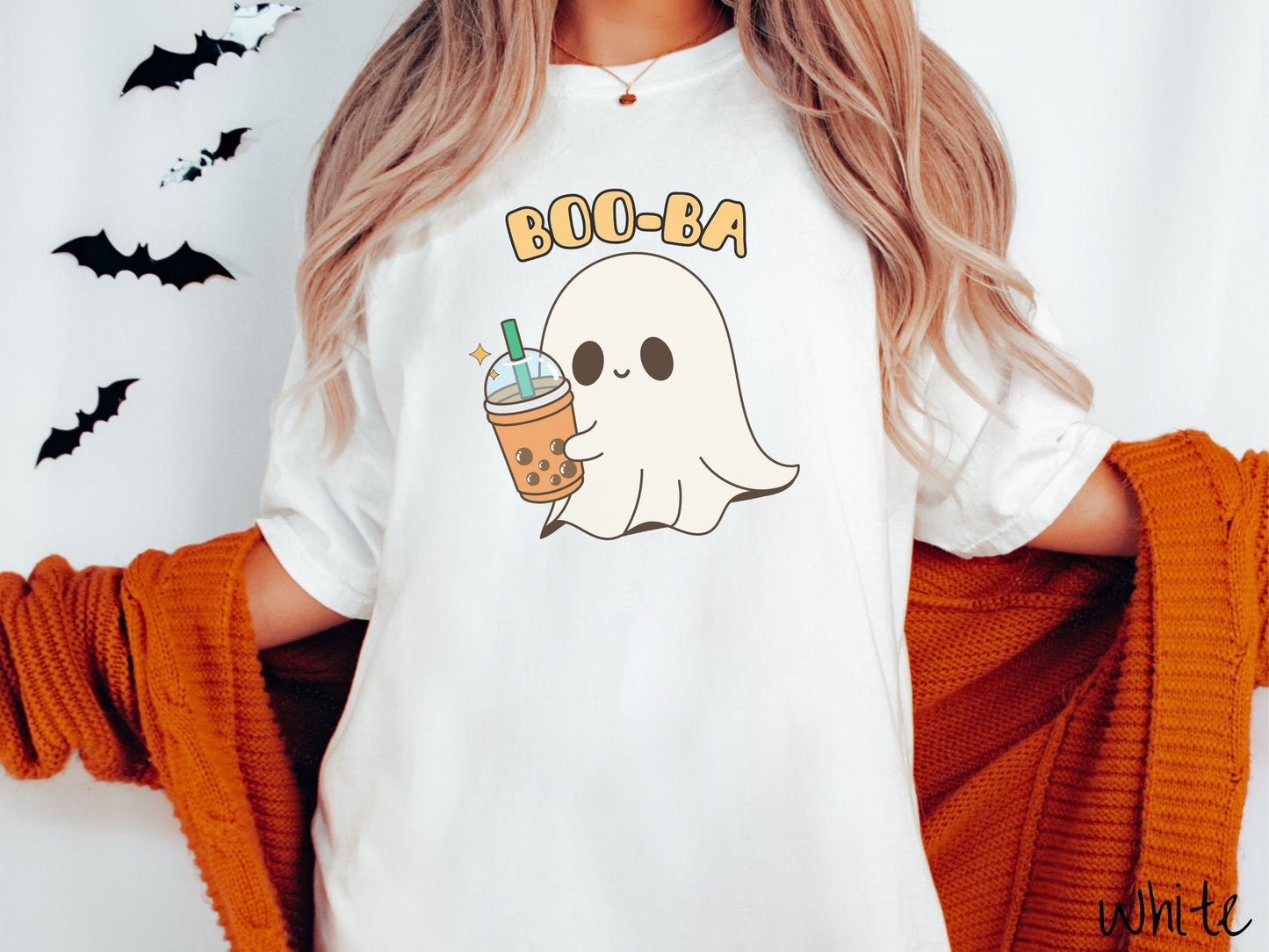 A woman wearing a cute, vintage white colored Comfort Colors T-shirt with the text Boo-Ba in yellow font across the top. Below is a little smiling white sheet ghost holding a light brown boba tea in a plastic to-go cup.