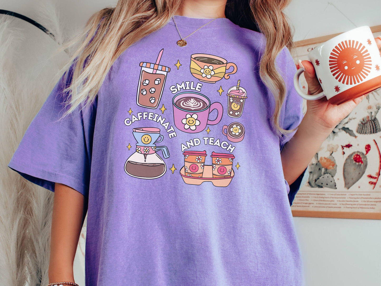 A woman wearing a cute, vintage violet colored Comfort Colors T-shirt with text Smile Caffeinate and Teach. There is an iced coffee, two cups of hot coffee, a blended coffee drink with whipped cream, to-go coffees, and a pot of coffee.