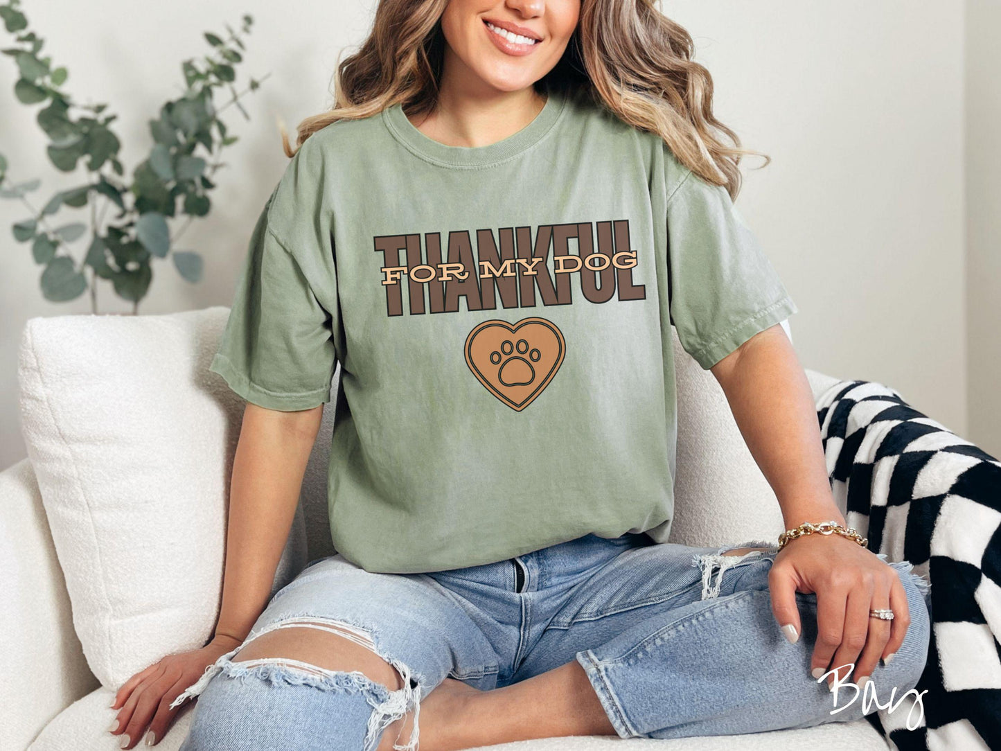 A woman wearing a cute, vintage bay colored Comfort Colors T-shirt with the text Thankful for My Dog across the top in two shades of brown. Below is a brown heart with a dog paw print in the middle.