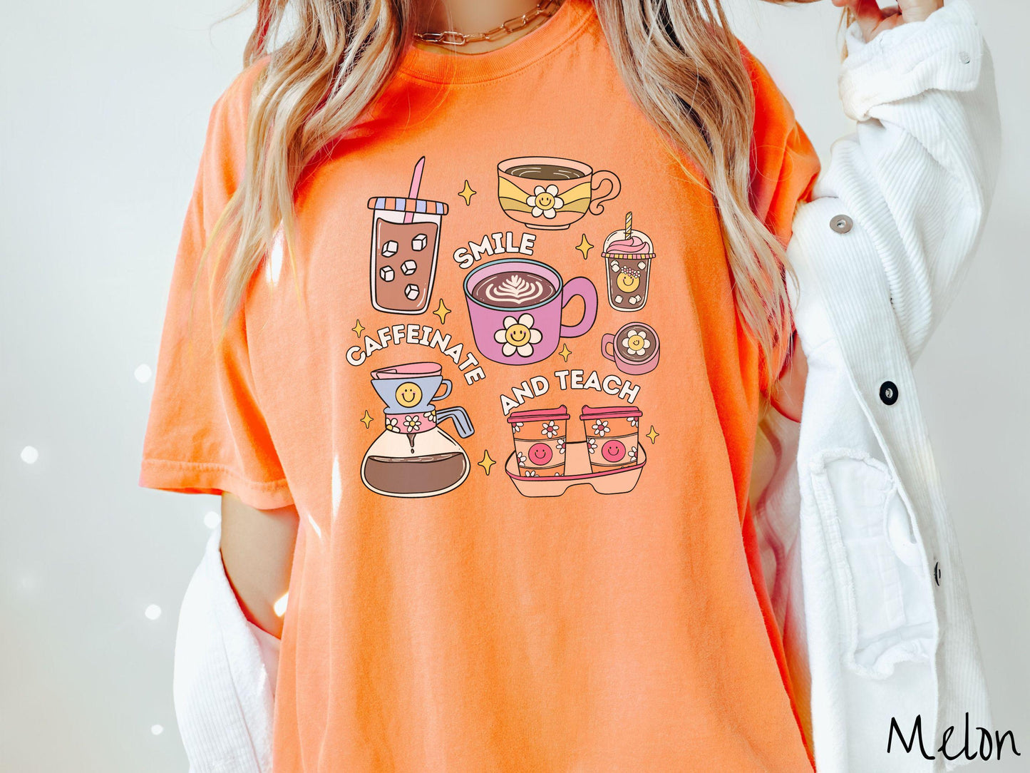 A woman wearing a cute, vintage melon colored Comfort Colors T-shirt with text Smile Caffeinate and Teach. There is an iced coffee, two cups of hot coffee, a blended coffee drink with whipped cream, to-go coffees, and a pot of coffee.