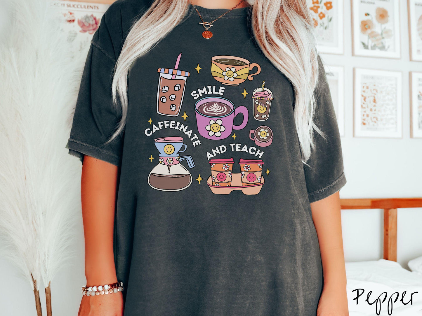 A woman wearing a cute, vintage pepper colored Comfort Colors T-shirt with text Smile Caffeinate and Teach. There is an iced coffee, two cups of hot coffee, a blended coffee drink with whipped cream, to-go coffees, and a pot of coffee.