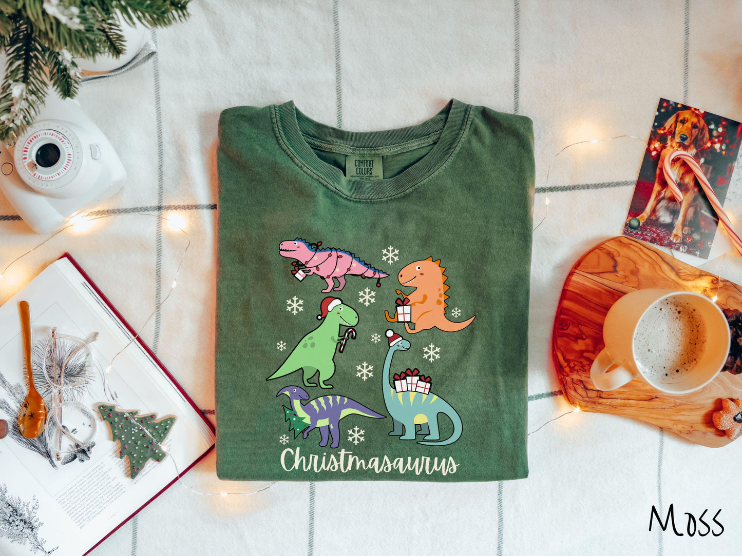Get into the festive spirit with this adorable moss colored Christmasaurus Comfort Colors T-shirt. Featuring a variety of colorful dinosaurs dressed up for the holidays, this tee exudes a playful and cheerful vibe.