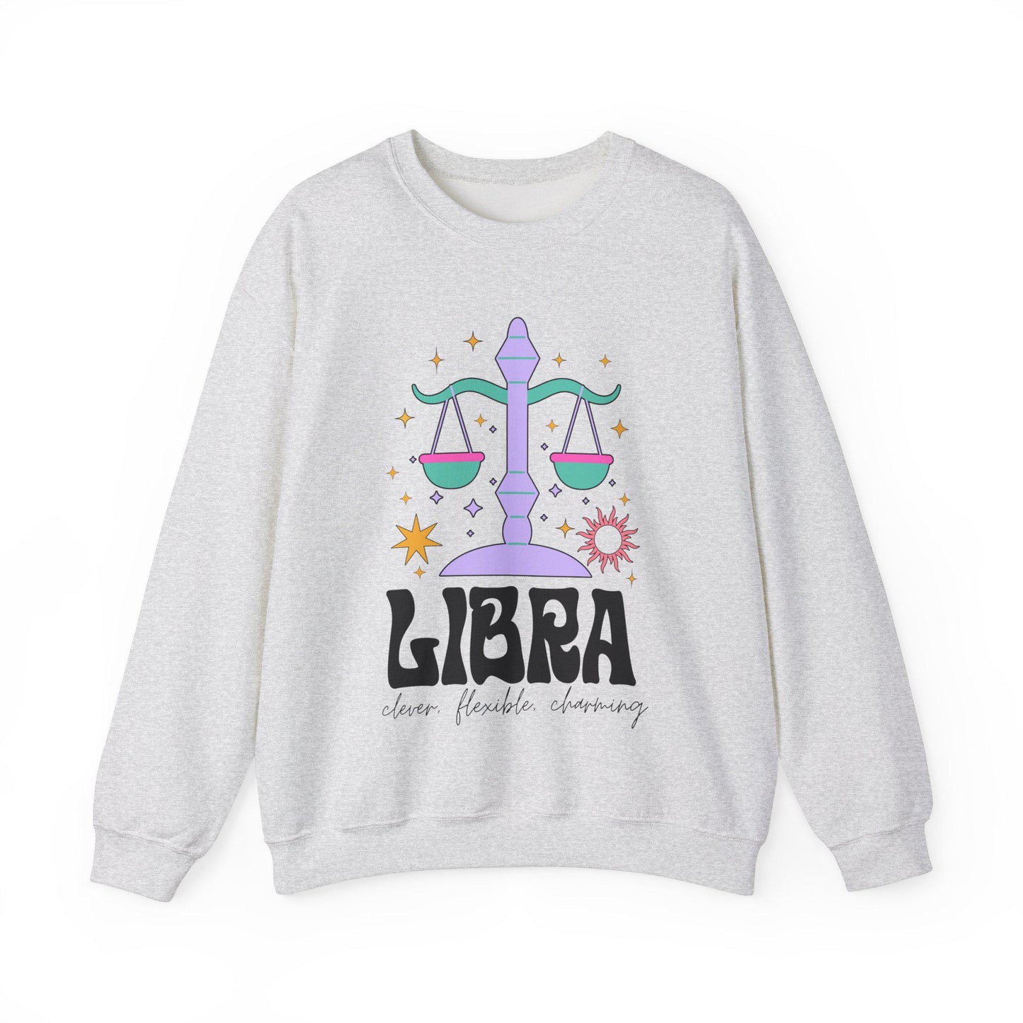 A vintage maroon colored Gildan sweatshirt features a large purple and green weight scale surrounded by stars and the sun with the text Libra in large bold font and below that are the words clever, flexible, charming in cursive font.