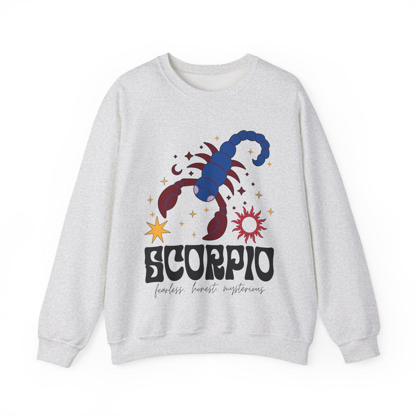 A vintage light pink colored Gildan sweatshirt features a large red and blue scorpion surrounded by stars and the sun with the text Scorpio in large bold font and below that are the words fearless, honest, mysterious in cursive font.