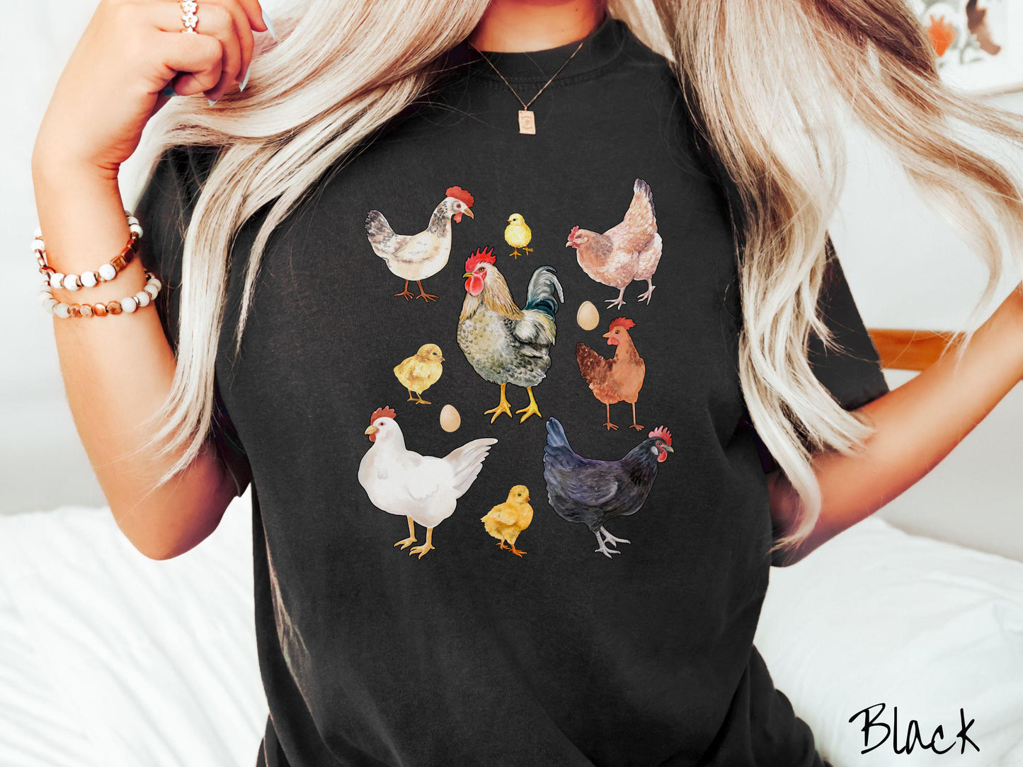 A vintage black colored Comfort Colors t-shirt featuring a grid style design of assorted colorful chickens, hens, and roosters in a grid design, with chicken eggs scattered among the design.