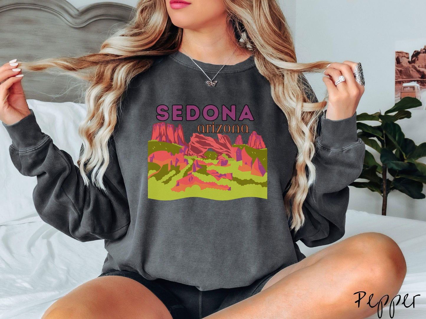 A colorful, vintage pepper colored Gildan sweatshirt with a scenic viewof Sedona, Arizona. There is an aerial view of the Devil's Bridge rock formation with greenery and rocks in the background.