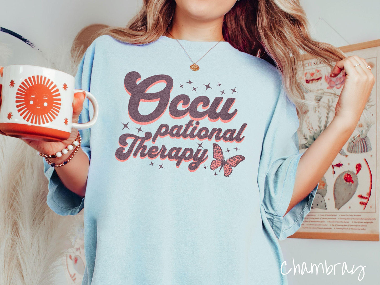 A vintage, chambray colored Comfort Colors t-shirt featuring the words Occupational Therapy across the front, this unique design showcases a stunning pink and dark purple butterfly surrounded by delicate twinkling stars.