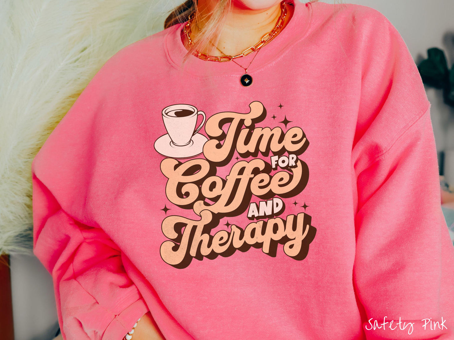 A vintage, safety pink colored Gildan sweatshirt featuring the text Time for Coffee and Therapy with a cup of coffee and stars in the background, giving off a cozy and comforting vibe.