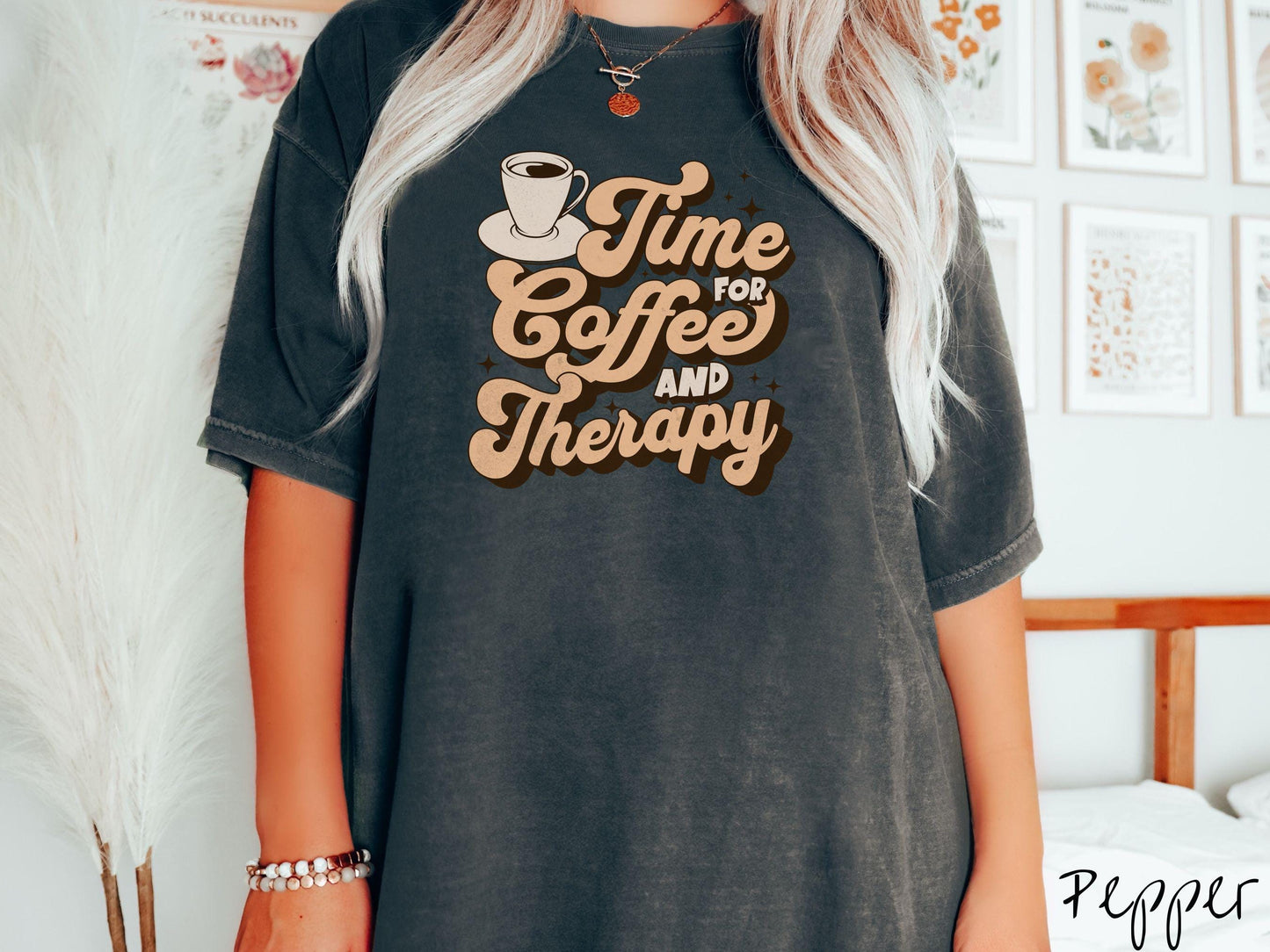 A vintage, pepper colored Comfort Colors t-shirt featuring the text Time for Coffee and Therapy with a cup of coffee and stars in the background, giving off a cozy and comforting vibe.