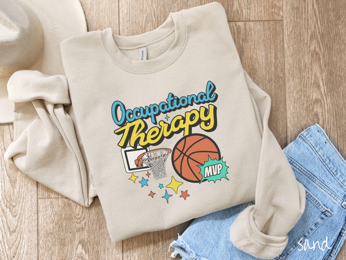 A vintage, sand colored Gildan sweatshirt features the phrase "Occupational Therapy" above a basketball goal, complemented by a bold basketball graphic with the text "MVP".