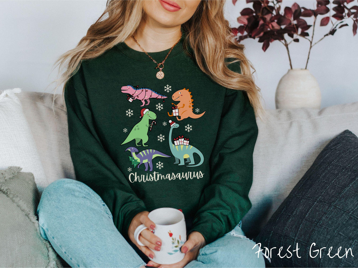 An adorable forest green colored Christmasaurus Gildan sweatshirt. Featuring a variety of colorful dinosaurs dressed up for the holidays, this sweater exudes a playful and cheerful vibe.