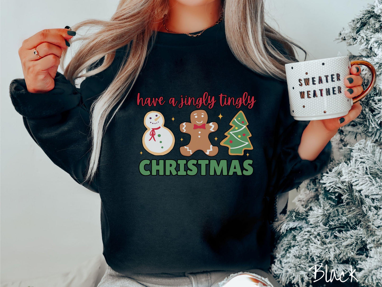 A vintage black colored Christmas Gildan sweatshirt featuring a snowman iced cookie, a gingerbread man cookie, and a Christmas tree cookie. The text reads 'have a jingly tingly Christmas' in red and green font.