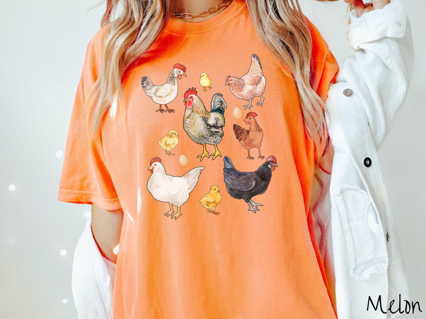 A vintage melon colored Comfort Colors t-shirt featuring a grid style design of assorted colorful chickens, hens, and roosters in a grid design, with chicken eggs scattered among the design.