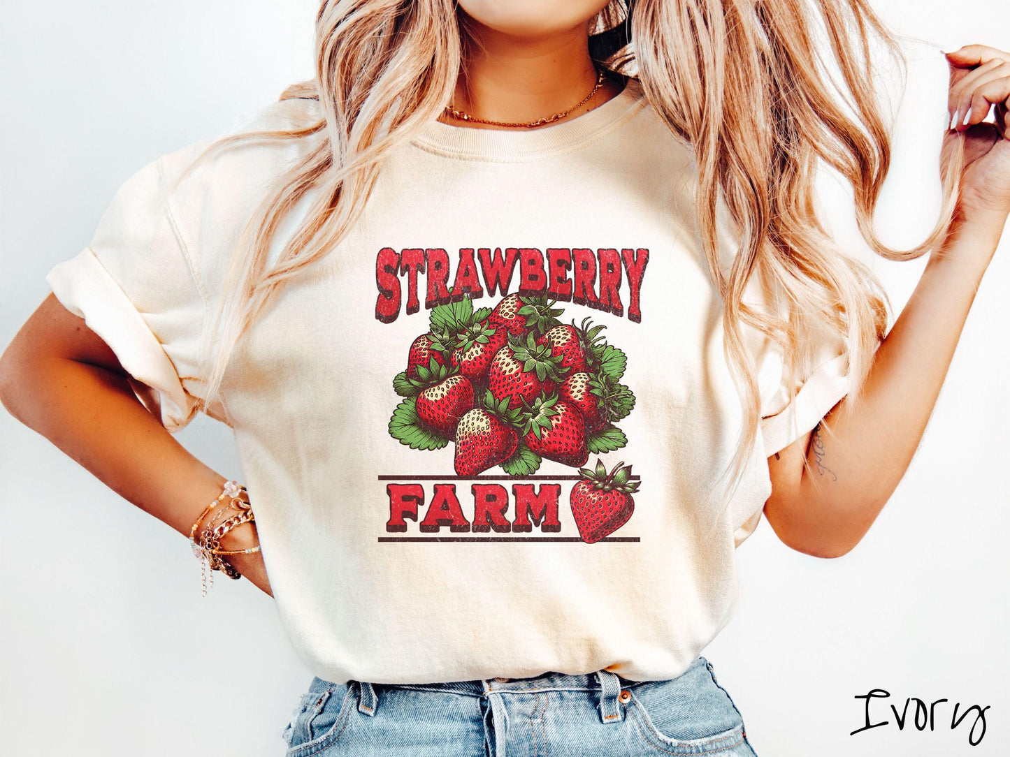 A vintage ivory colored Comfort Colors t-shirt featuring the text Strawberry Farm in red font with a bundle of red strawberries in between the text.