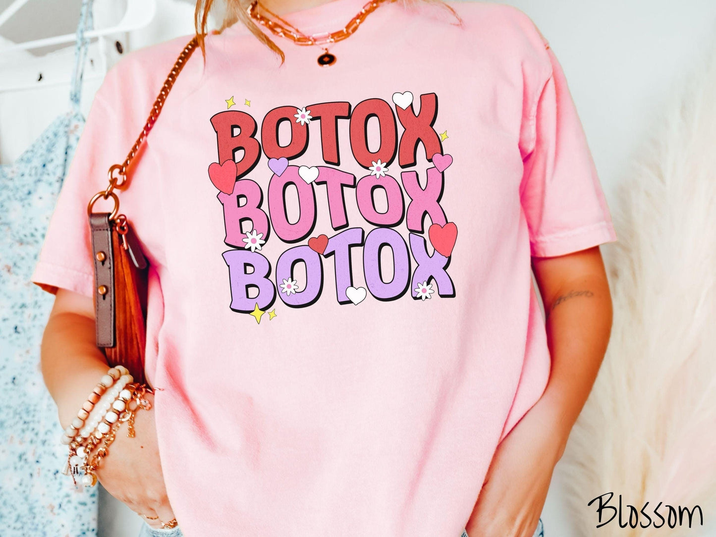 A vibrant Comfort Colors T-shirt with the text BOTOX written three times vertically, accompanied by tiny hearts, stars, and flowers. The perfect gift for friends who are into cosmetic botox nursing.