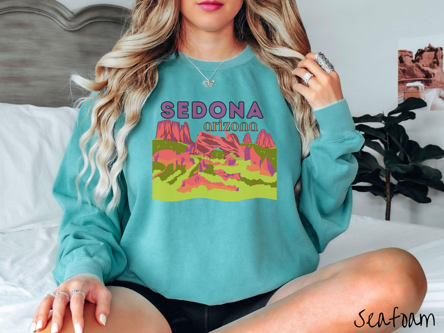A colorful, vintage seafoam colored Gildan sweatshirt with a scenic viewof Sedona, Arizona. There is an aerial view of the Devil's Bridge rock formation with greenery and rocks in the background.