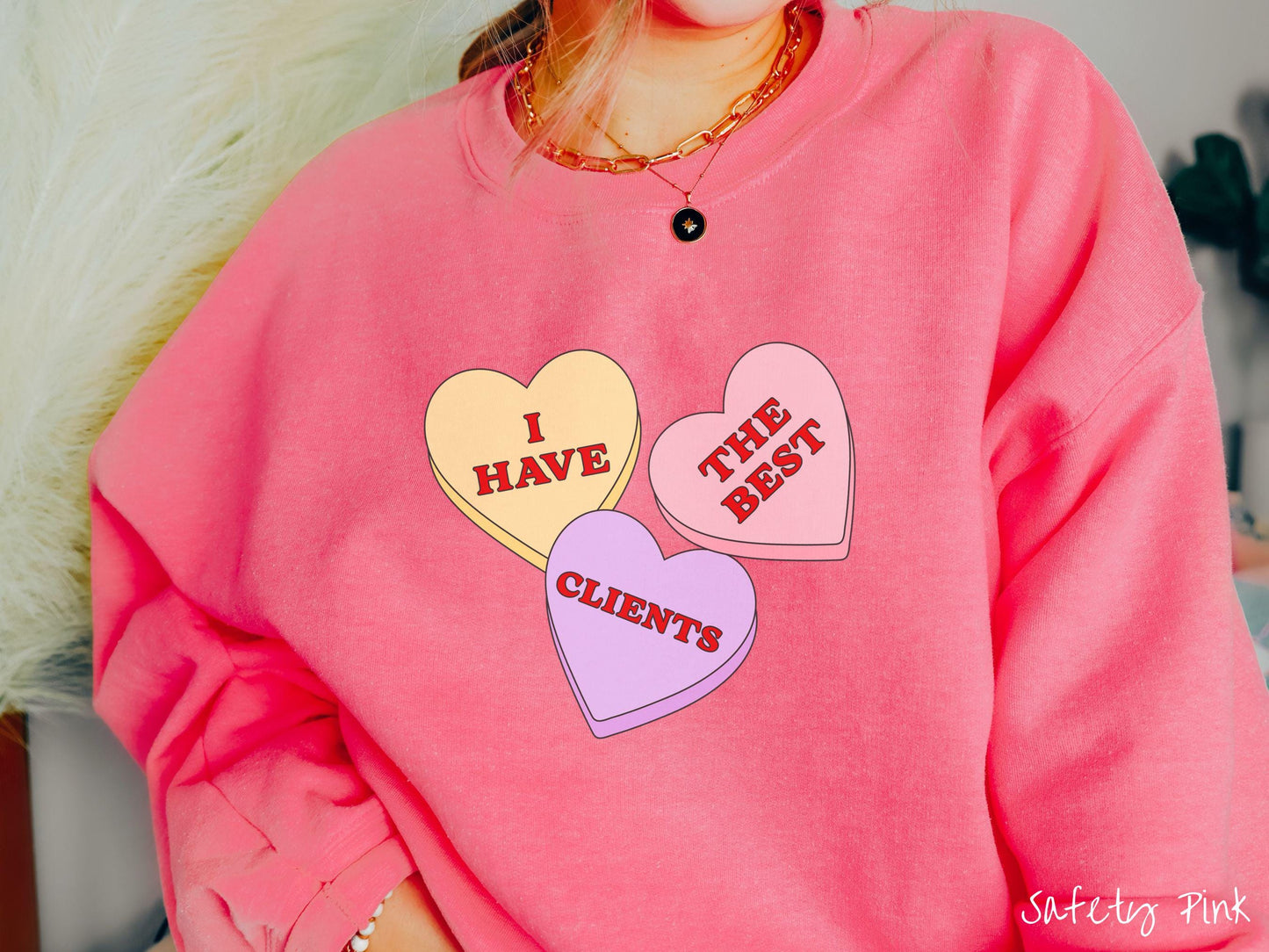 Show your appreciation for your amazing clients with this charming Gildan sweatshirt featuring three vibrant conversation hearts in yellow, red, and purple colors showcasing the text “I have the best clients” spread across the hearts.