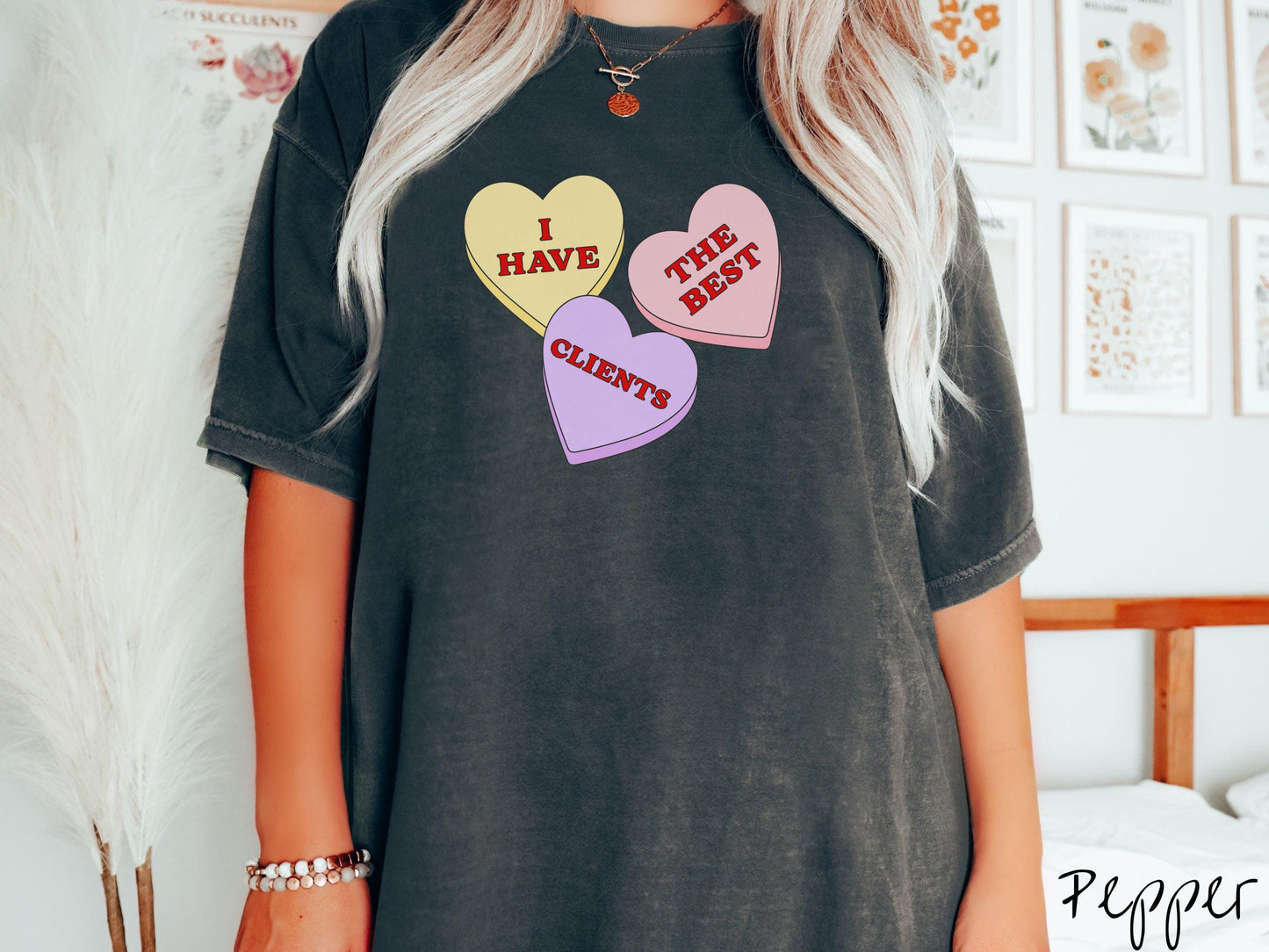 Show your appreciation for your amazing clients with this charming Comfort Colors t-shirt featuring three vibrant conversation hearts in yellow, red, and purple colors showcasing the text “I have the best clients” spread across the hearts.