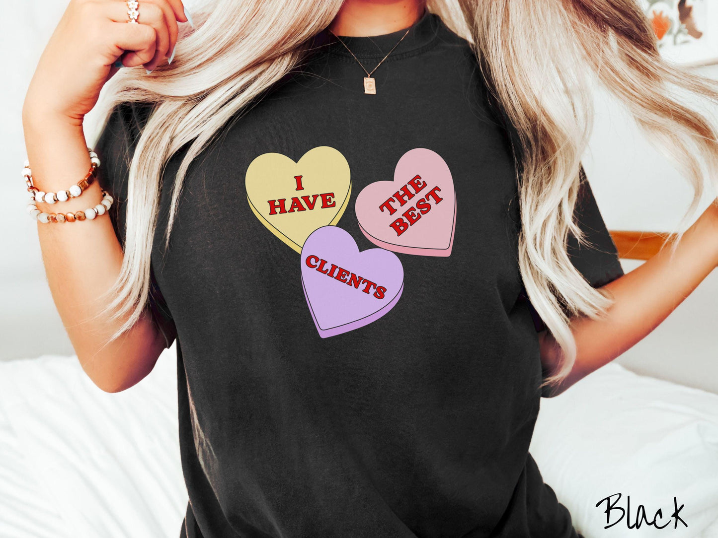 Show your appreciation for your amazing clients with this charming Comfort Colors t-shirt featuring three vibrant conversation hearts in yellow, red, and purple colors showcasing the text “I have the best clients” spread across the hearts.