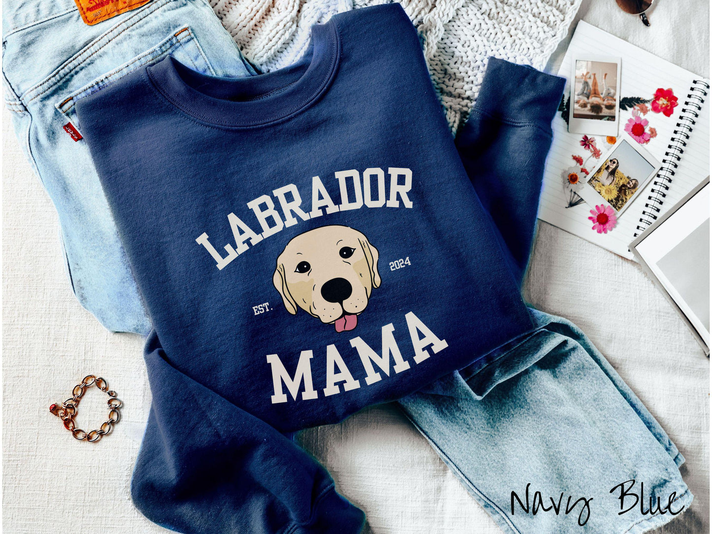 A vintage Gildan sweatshirt featuring bold block lettering that reads 'Labrador Mama.' At the center of the design, a playful yellow Labrador with its tongue out steals the spotlight, framed by the stylish text 'EST. 2024.'