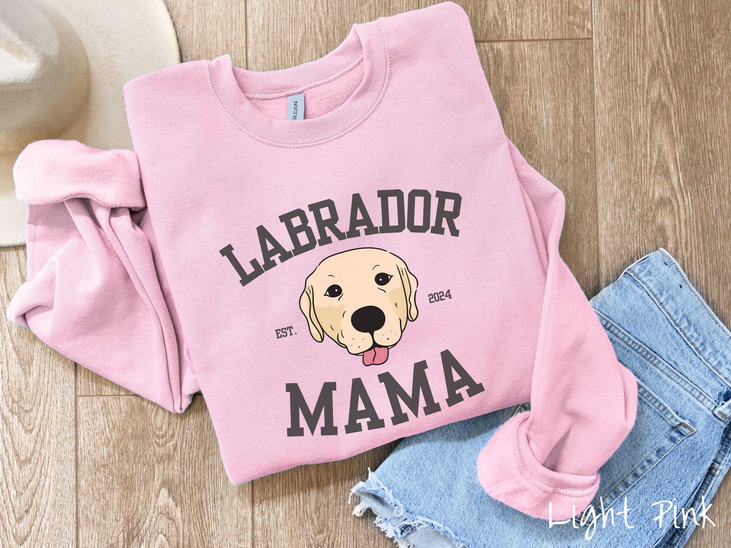 A vintage Gildan sweatshirt featuring bold block lettering that reads 'Labrador Mama.' At the center of the design, a playful yellow Labrador with its tongue out steals the spotlight, framed by the stylish text 'EST. 2024.'