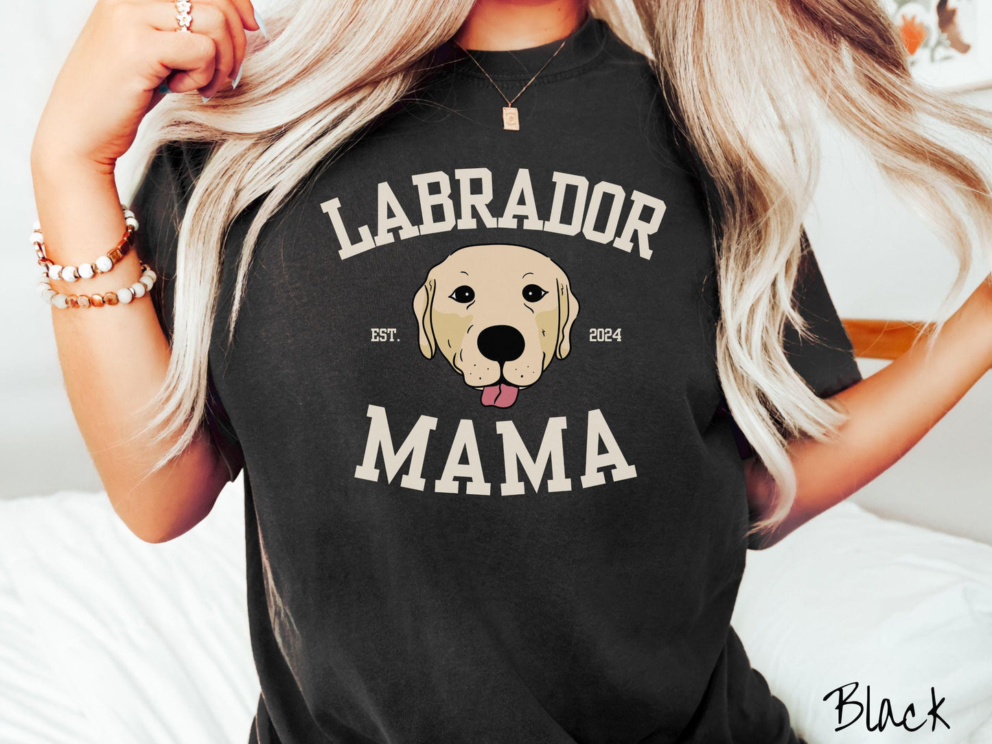 A vintage Comfort Colors t-shirt featuring bold block lettering that reads 'Labrador Mama.' At the center of the design, a playful yellow Labrador with its tongue out steals the spotlight, framed by the stylish text 'EST. 2024.'